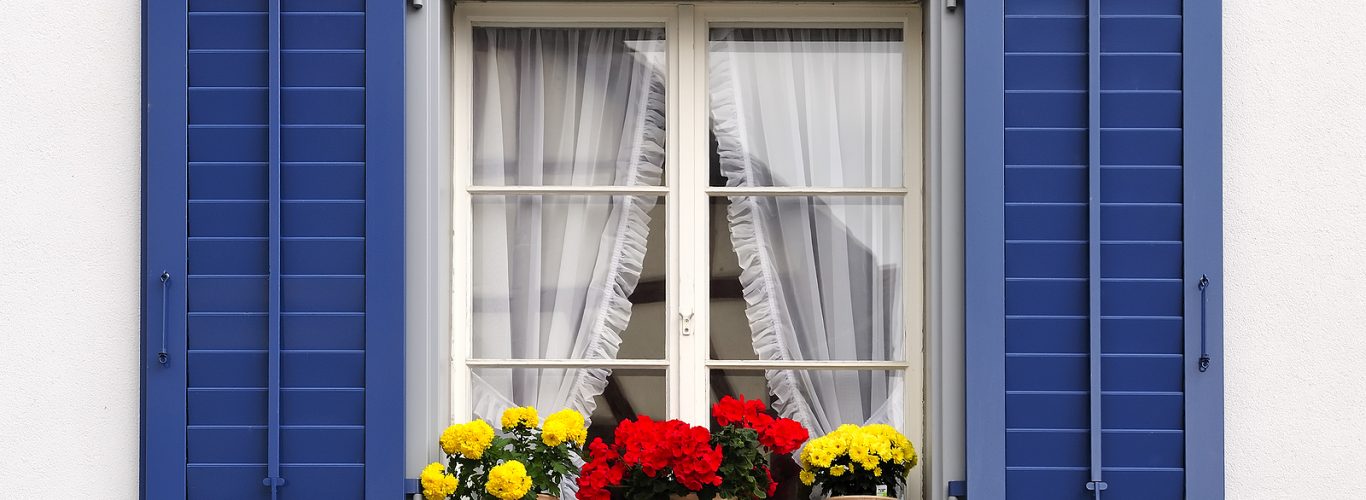 solid wood shutters - windows with flowers in hanging flower pots