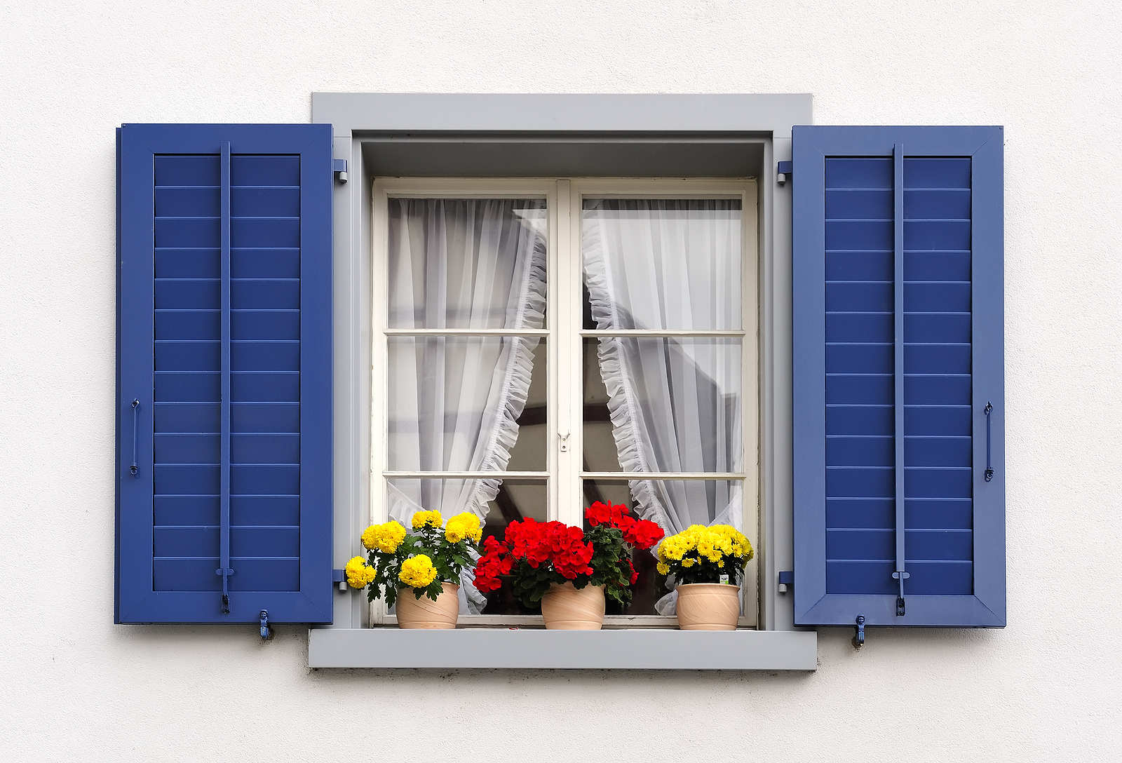 solid wood shutters - windows with flowers in hanging flower pots