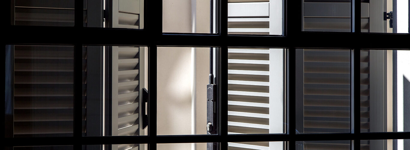 Solid wood shutters - gray wooden shutters on a sunny day view